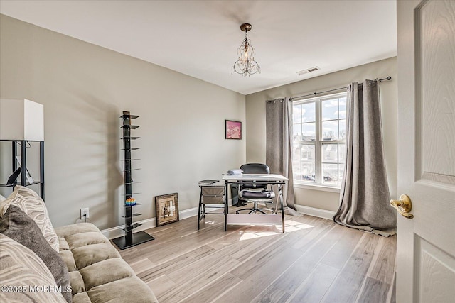 home office with a notable chandelier, baseboards, visible vents, and light wood-type flooring