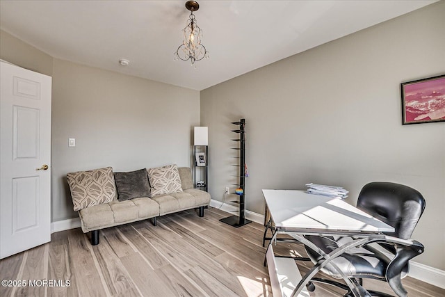 office space featuring a notable chandelier, light wood-type flooring, and baseboards