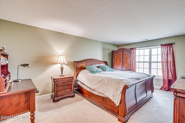 bedroom featuring visible vents, light colored carpet, and baseboards