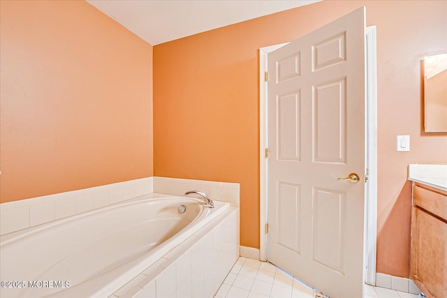 bathroom with vanity, tile patterned floors, a garden tub, and baseboards