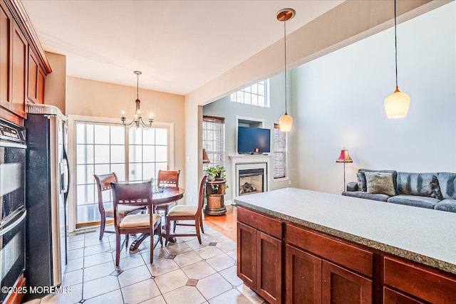 kitchen with hanging light fixtures, a fireplace, open floor plan, and freestanding refrigerator