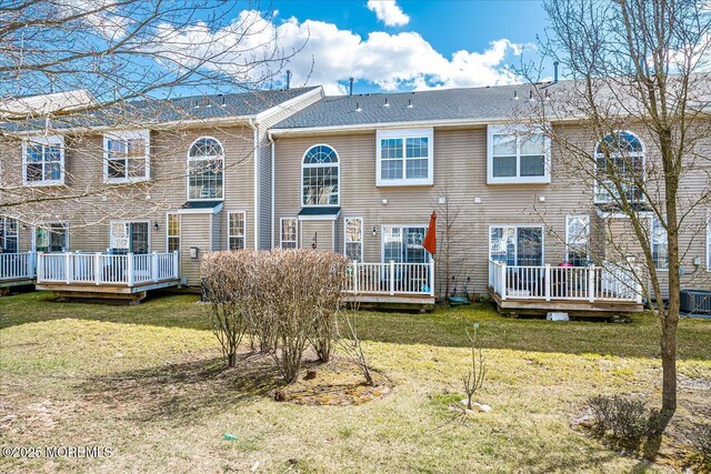 rear view of property featuring a yard and a wooden deck