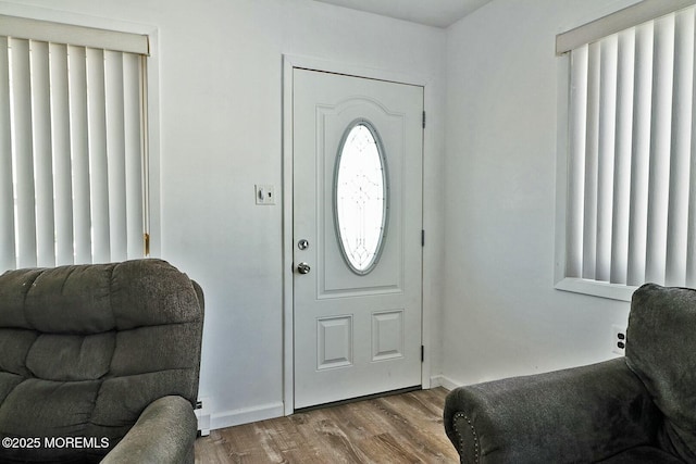 foyer with baseboards and wood finished floors