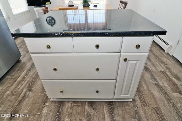 room details with a baseboard heating unit and wood finished floors