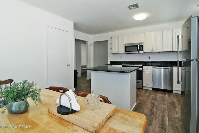 kitchen featuring dark countertops, visible vents, appliances with stainless steel finishes, and white cabinetry