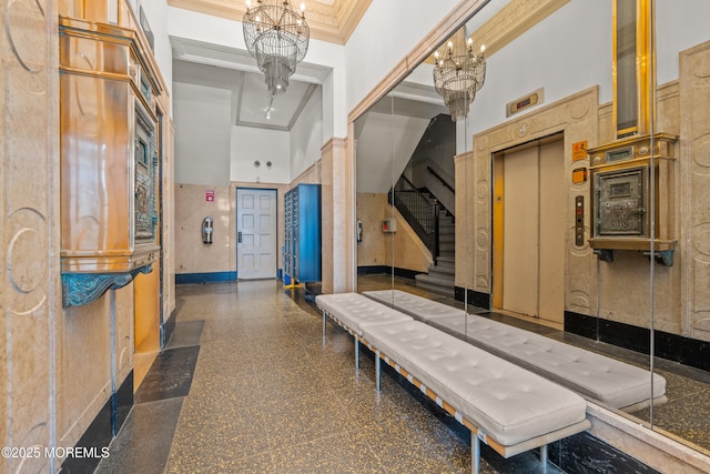 interior space with crown molding, baseboards, a chandelier, a high ceiling, and granite finish floor