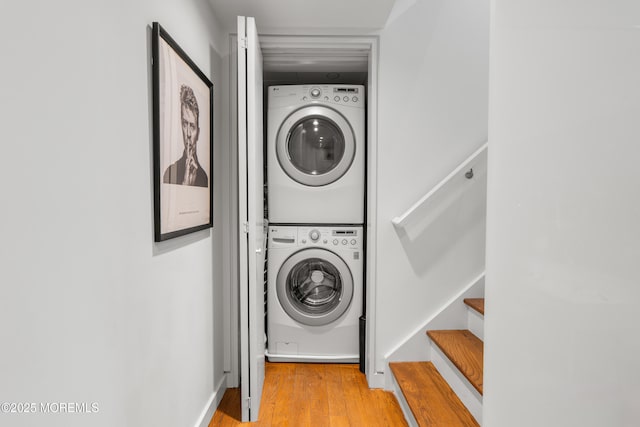 laundry room featuring light wood-style flooring, laundry area, and stacked washer / dryer