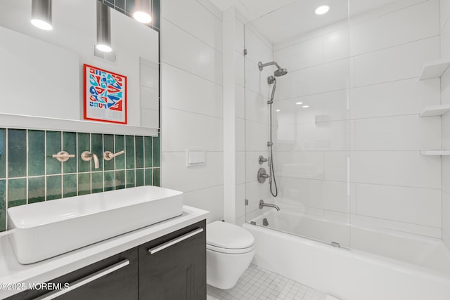 bathroom featuring tile patterned flooring, tile walls, toilet, bathing tub / shower combination, and vanity