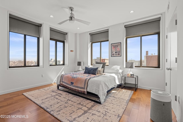 bedroom with hardwood / wood-style flooring, recessed lighting, visible vents, and baseboards