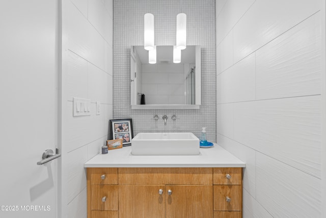 bathroom featuring decorative backsplash, tile walls, and vanity