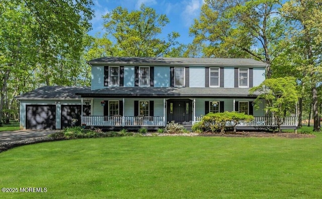 view of front of home featuring driveway, a front lawn, covered porch, and an attached garage