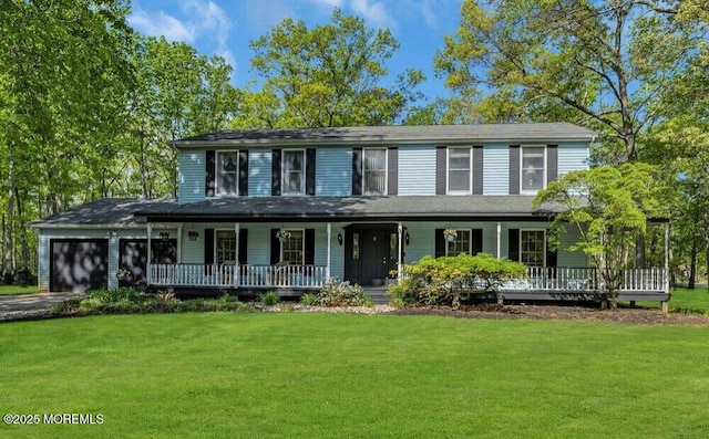 view of front of property featuring a front lawn, an attached garage, covered porch, and aphalt driveway