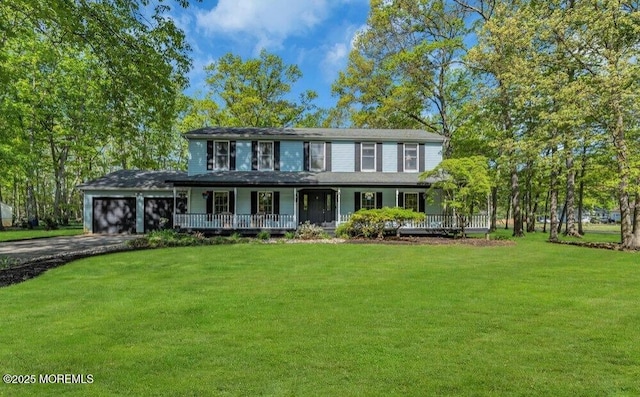 view of front facade featuring a front lawn, an attached garage, covered porch, and driveway