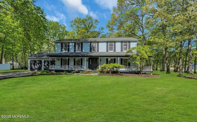 view of front of house featuring a porch, an attached garage, driveway, and a front lawn