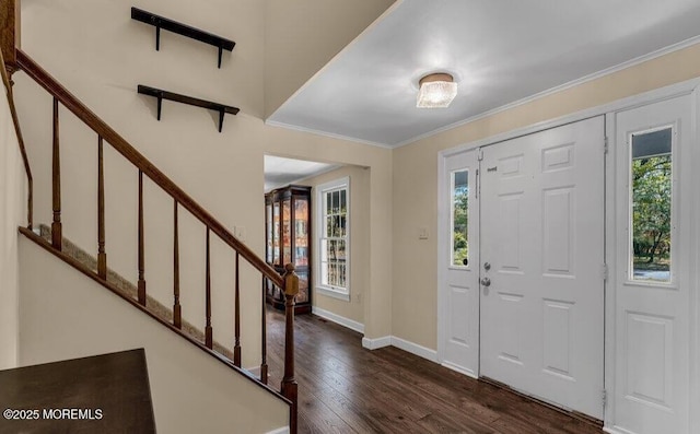 entrance foyer featuring dark wood-style floors, stairs, baseboards, and ornamental molding