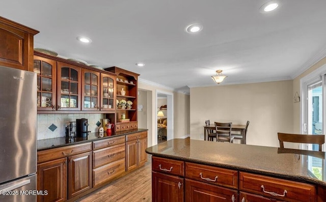 kitchen with backsplash, glass insert cabinets, crown molding, freestanding refrigerator, and open shelves