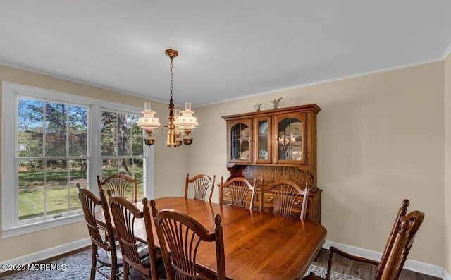 dining area featuring an inviting chandelier, baseboards, and ornamental molding