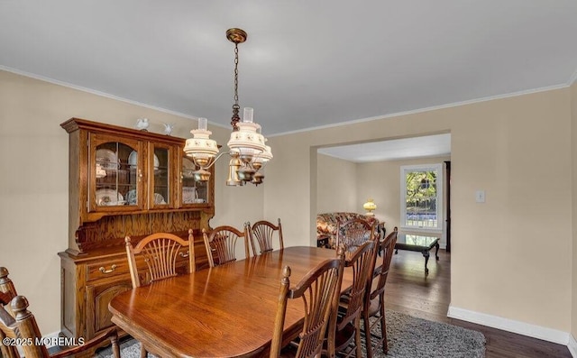 dining space with a chandelier, crown molding, baseboards, and dark wood-style flooring