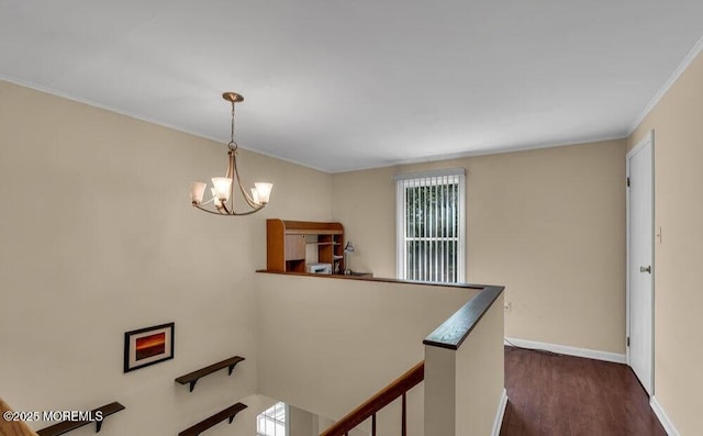 hall featuring crown molding, dark wood-type flooring, baseboards, an upstairs landing, and a notable chandelier