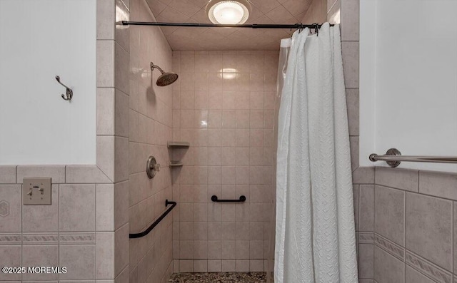 bathroom featuring a tile shower and tile walls