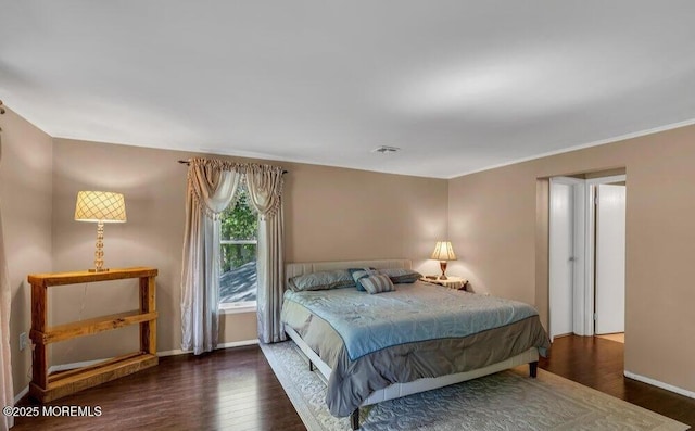 bedroom with visible vents, baseboards, and wood finished floors