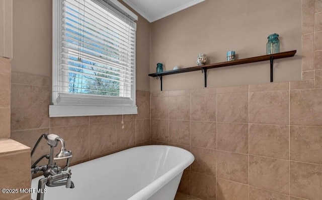 full bathroom with tile walls, a freestanding tub, and ornamental molding