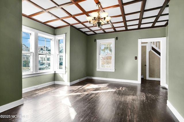 unfurnished room featuring wood-type flooring, coffered ceiling, a notable chandelier, and baseboards