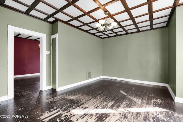 empty room with coffered ceiling, visible vents, a notable chandelier, and baseboards