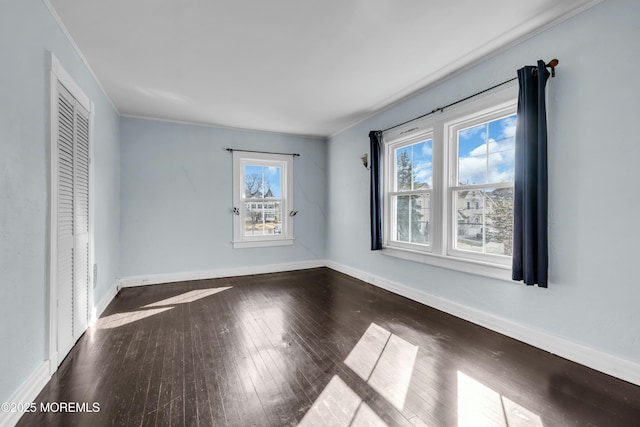 interior space with wood-type flooring, crown molding, and baseboards