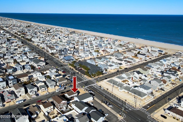 drone / aerial view featuring a residential view, a water view, and a view of the beach