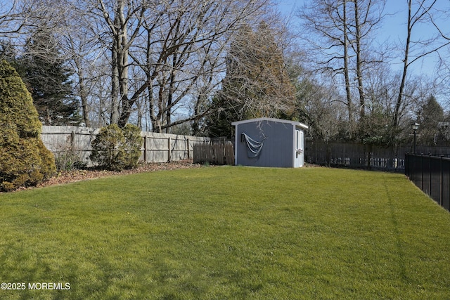 view of yard with an outbuilding, a shed, and a fenced backyard