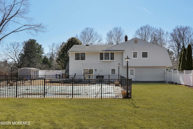 rear view of property with a patio area, a yard, a fenced backyard, and an outdoor structure