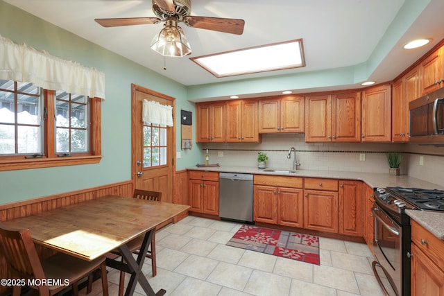 kitchen featuring brown cabinets, appliances with stainless steel finishes, and a sink