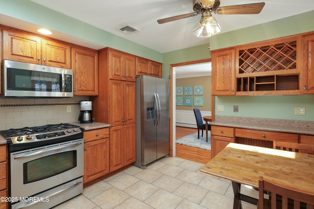 kitchen with visible vents, decorative backsplash, brown cabinetry, stainless steel appliances, and open shelves