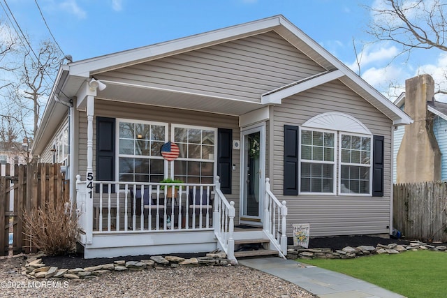 view of front facade with a porch and fence