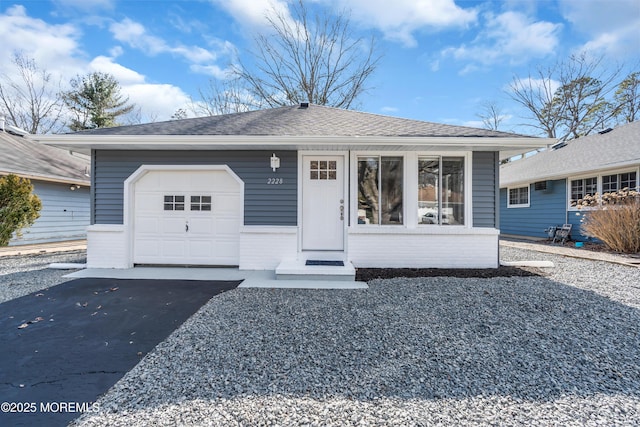 view of front facade featuring brick siding, a garage, driveway, and roof with shingles