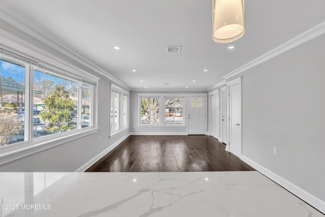 interior space featuring crown molding, plenty of natural light, baseboards, and visible vents