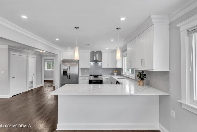 kitchen featuring a sink, light stone counters, appliances with stainless steel finishes, wall chimney exhaust hood, and white cabinets