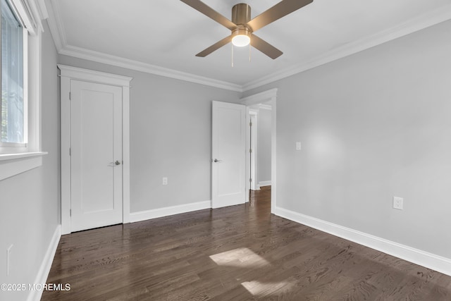 unfurnished bedroom with dark wood finished floors, a ceiling fan, baseboards, and ornamental molding