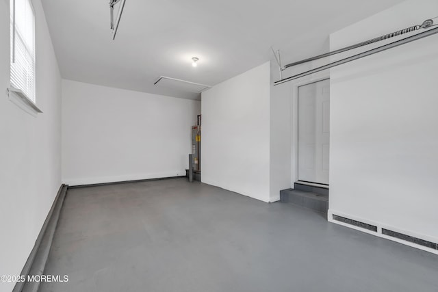 garage with a baseboard radiator and water heater