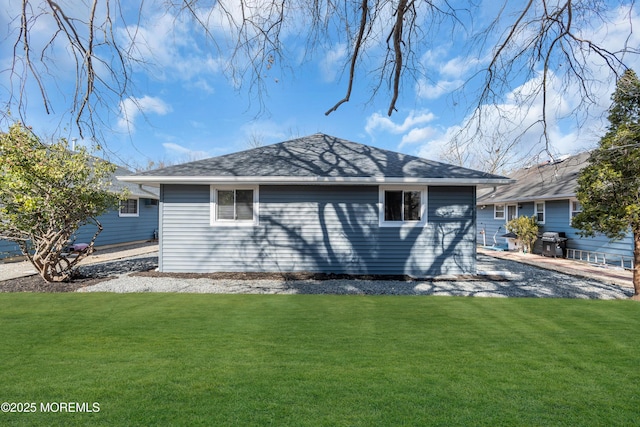 view of home's exterior featuring a yard and roof with shingles