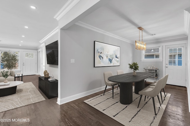 dining room featuring dark wood-type flooring, crown molding, baseboards, and visible vents