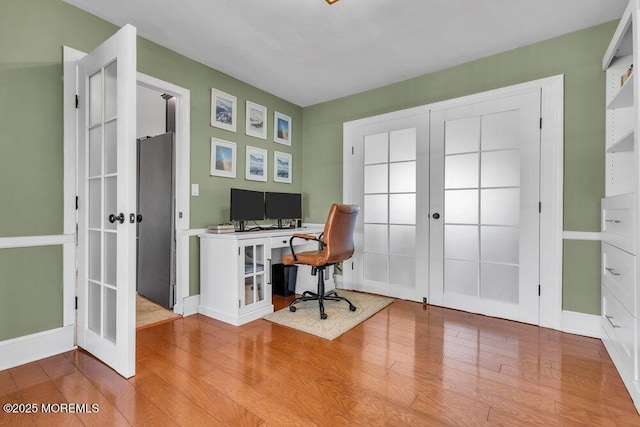 office space featuring wood finished floors, french doors, and baseboards