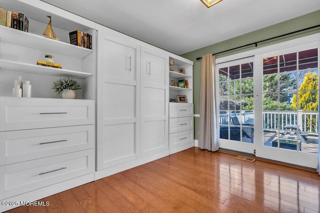 interior space with light wood finished floors and visible vents