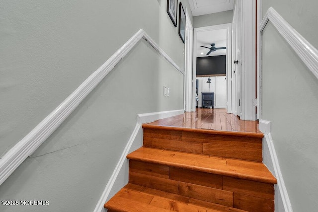 staircase with baseboards and wood finished floors