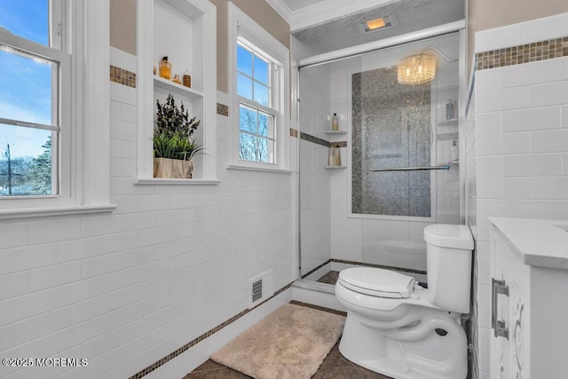 bathroom with tile walls, toilet, and a shower stall