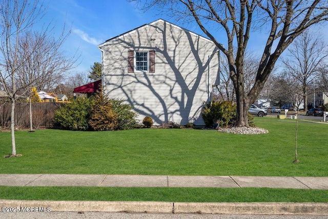 view of home's exterior with a yard and fence