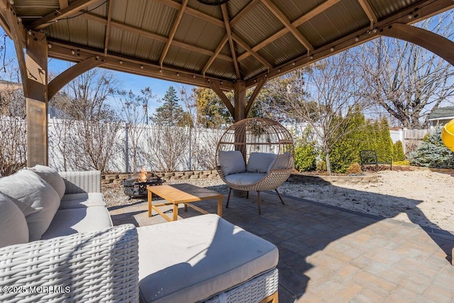 view of patio / terrace with a gazebo, an outdoor living space with a fire pit, and a fenced backyard