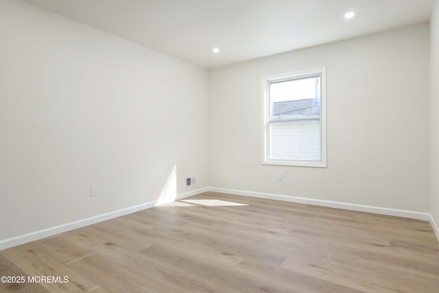 spare room with light wood finished floors, recessed lighting, and baseboards