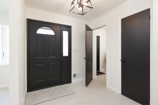 foyer entrance with a healthy amount of sunlight, visible vents, and baseboards